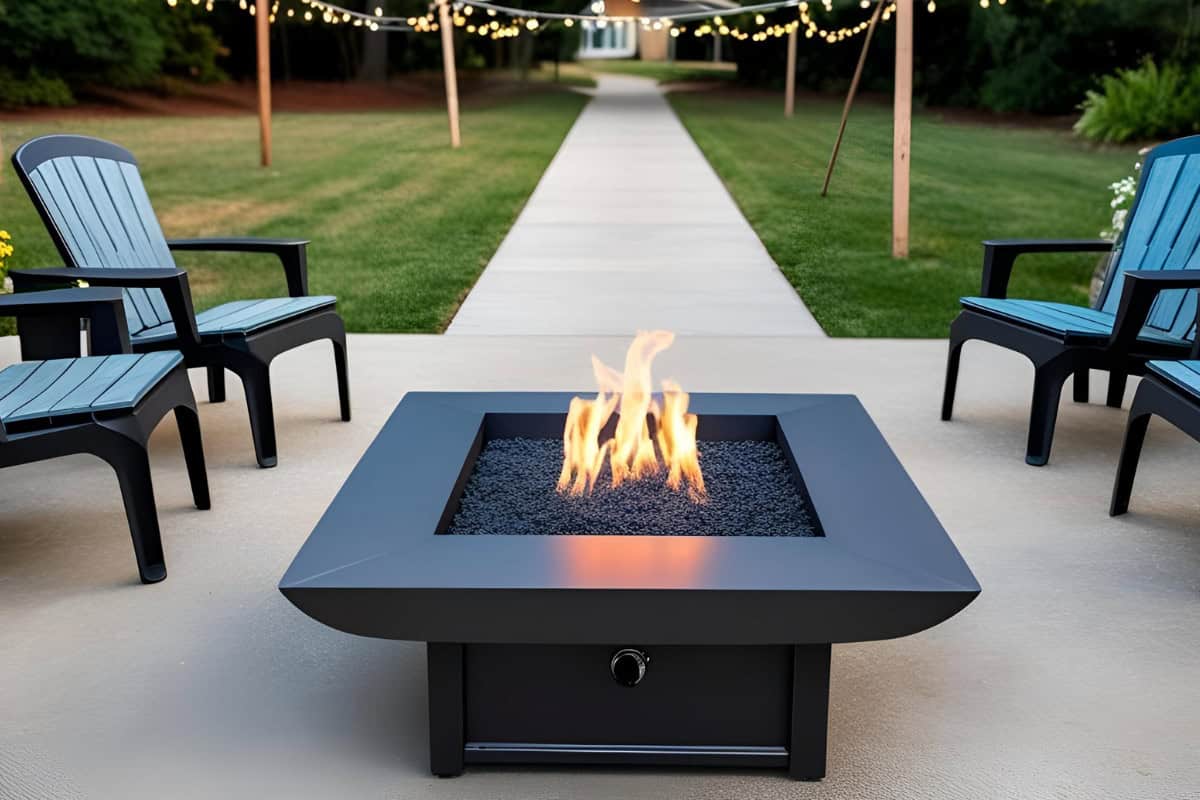 Image of a square gas fire pit at the end of a long path for a blog post on fire pit placement.