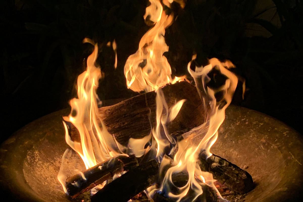 Image of a burning fire pit at night.