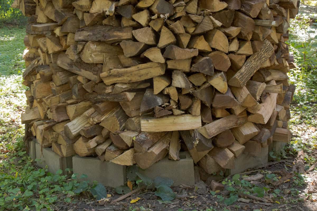how-to-stack-firewood-faq Image of wood stacked in Holz-hausen form for a blog post on how to stack firewood.