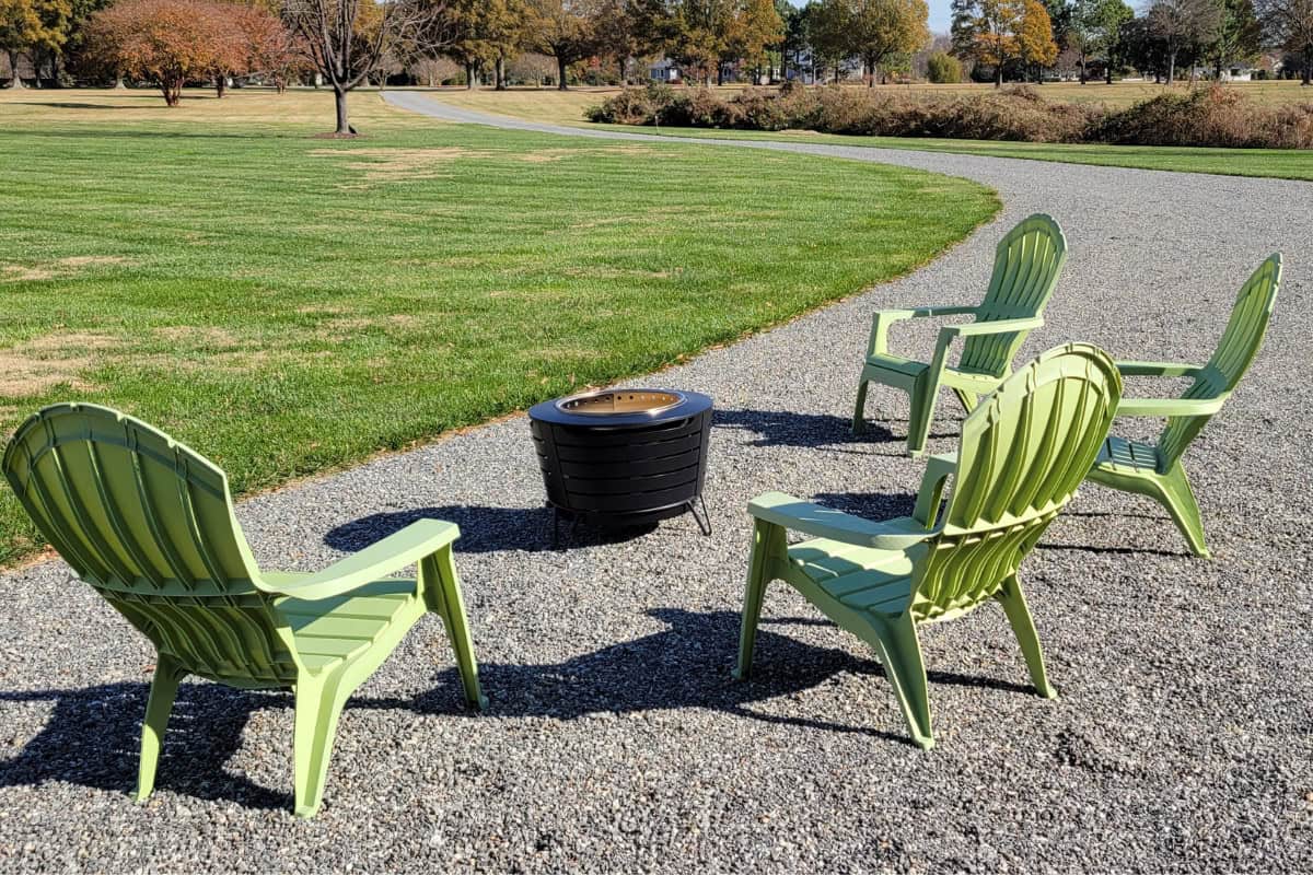 Image of a smokeless fire pit on gravel surrounded by chairs for a blog post covering the benefits of a fire pit.