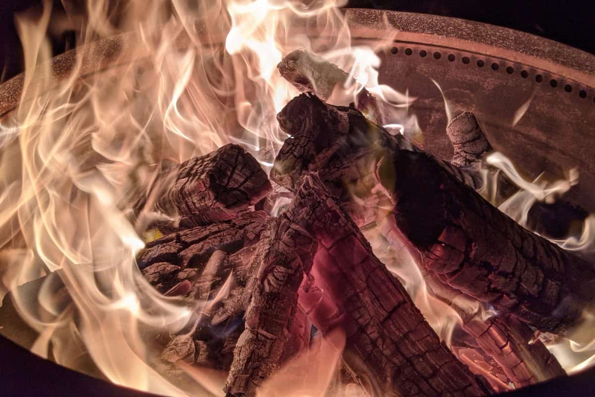 Image of a large smokeless fire pit burning at night.