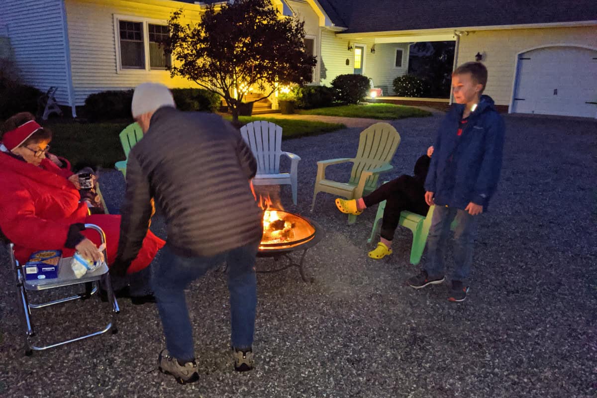 Image of a family gathered around a fire pit in winter.