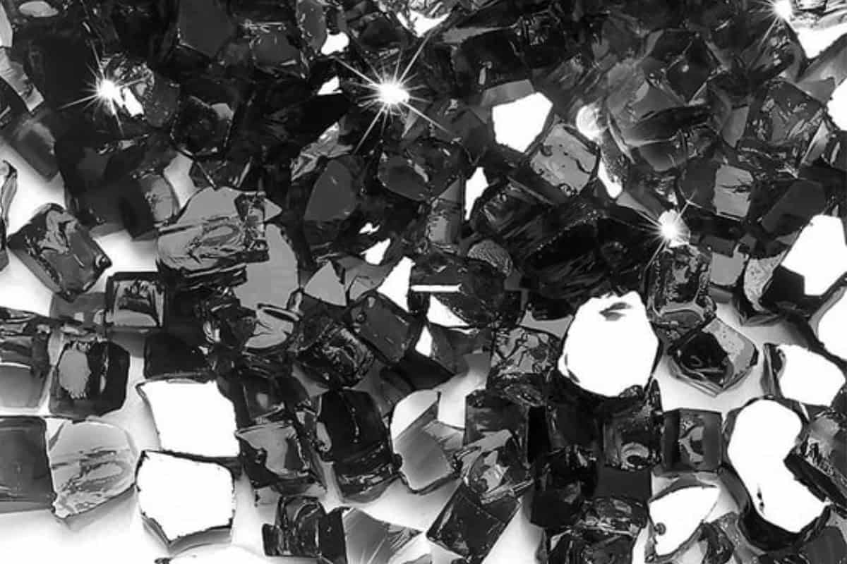 Image of a pile of shiny black fire glass for a blog post covering how much fire glass is needed for a fire pit.