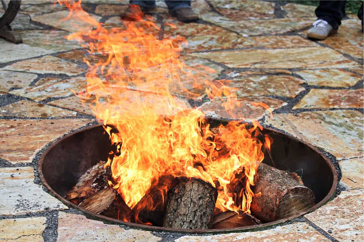 Image of a built-in wood burning fire pit on a tile patio.