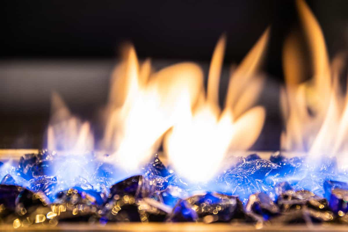 Image of a burning fire pit with black fireglass.