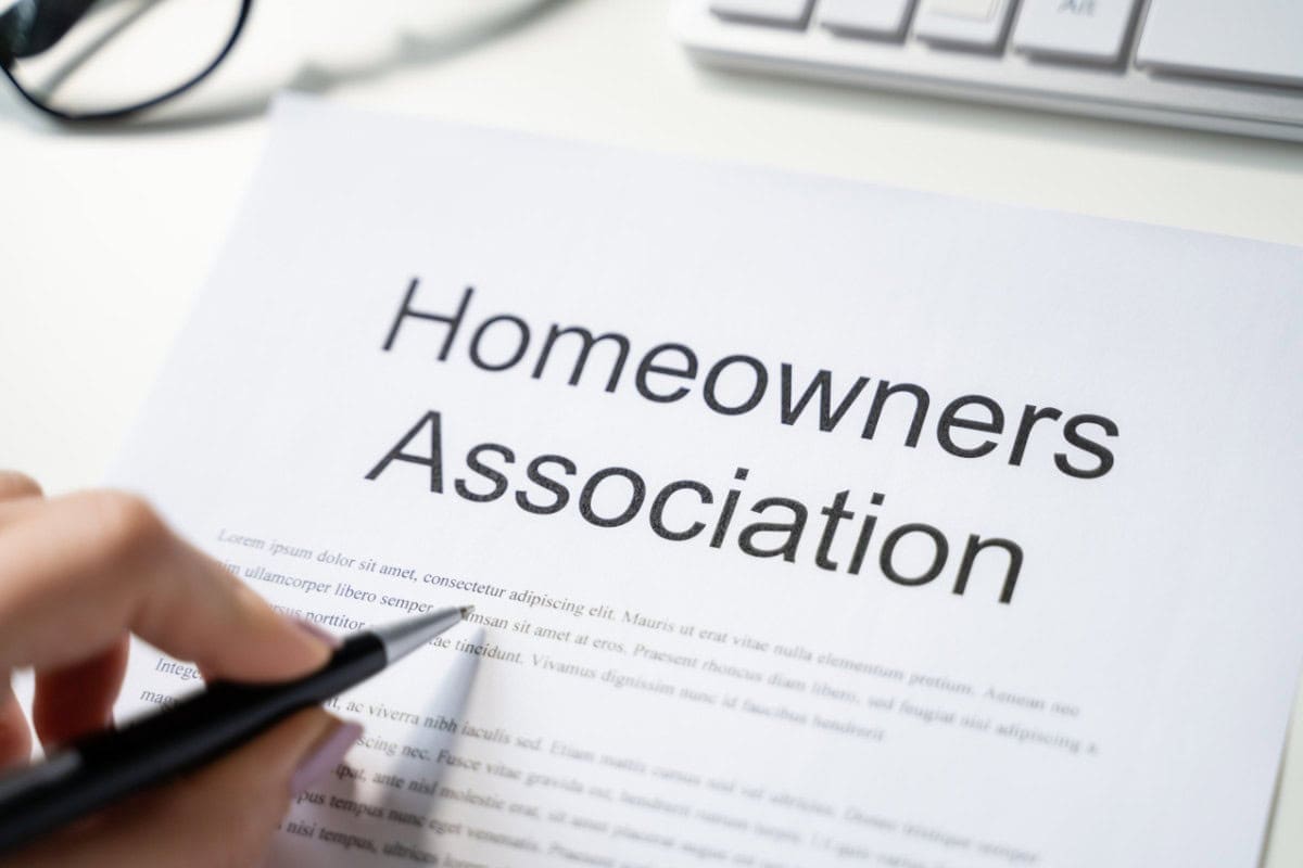 fire-pit-on-decking-considerations Image of a HOA document and a hand with a pen.