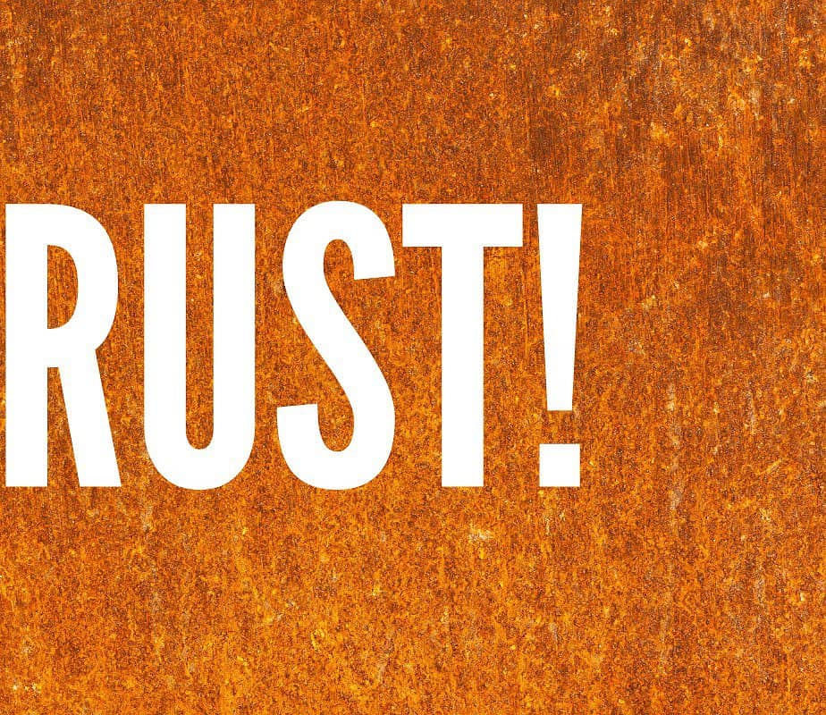 Image of the word rust with a rusty fire pit background