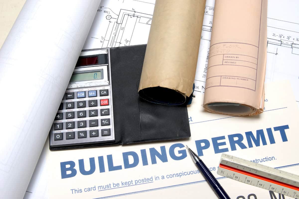 Image of blueprint and a building permit on a desk.