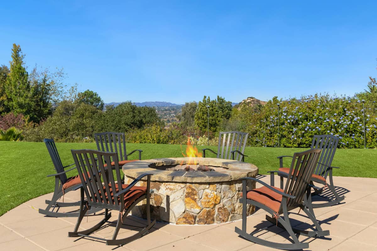 Image of a wood burning masonry fire pit in a backyard.