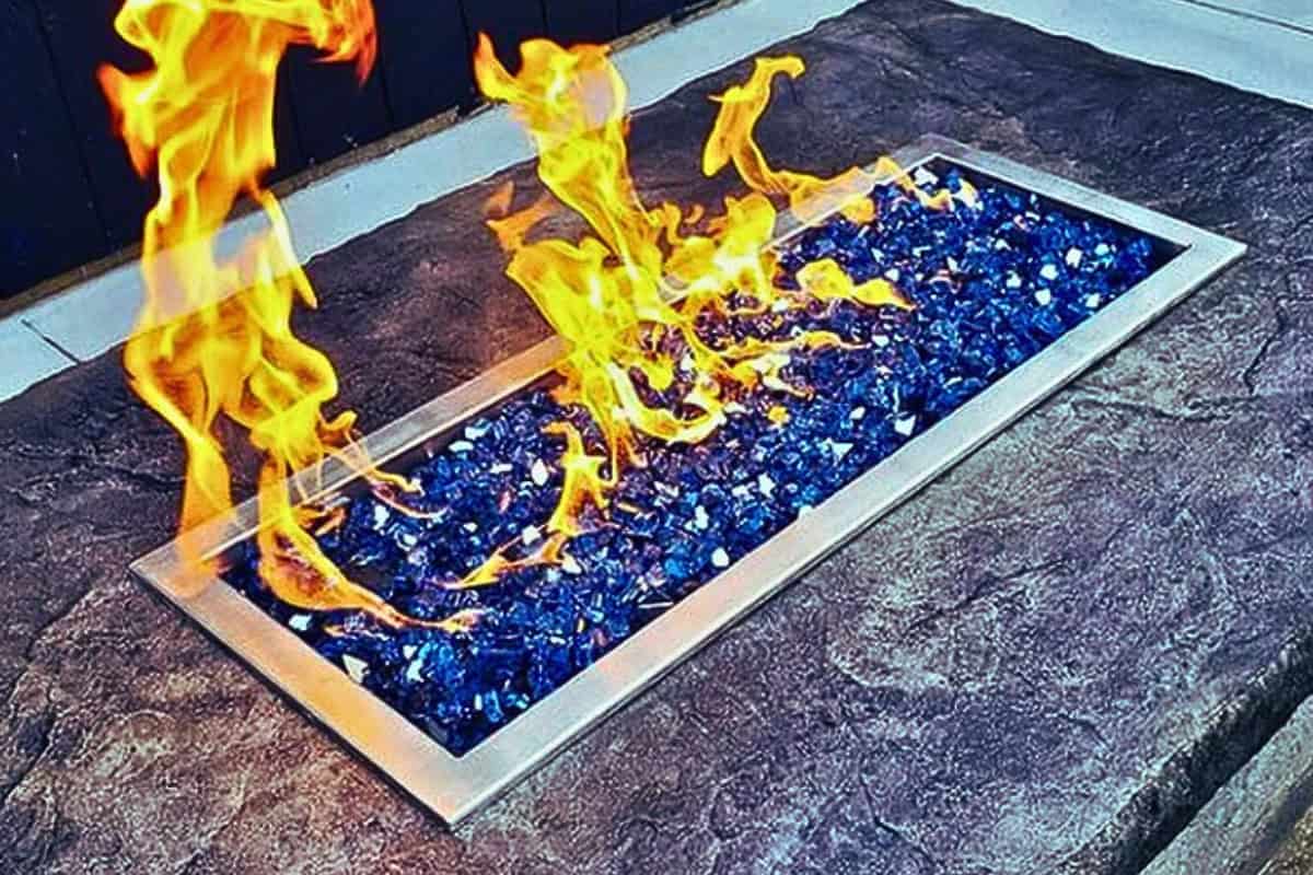 Image of a gas fire pit burner with blue fire glass.