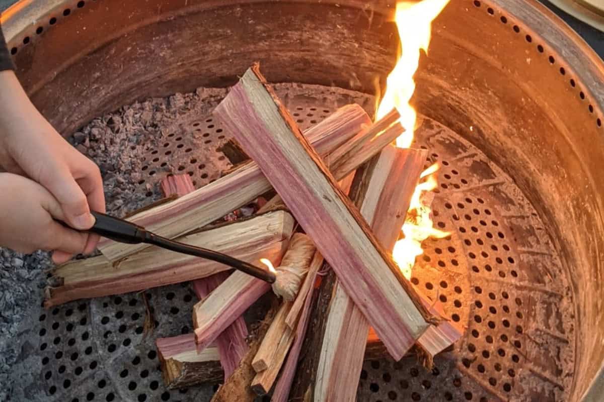 best-fire-pit-fuels-main Image of the lighting of a wood burning smokeless fire pit for a blog post covering various fire pit fuels.