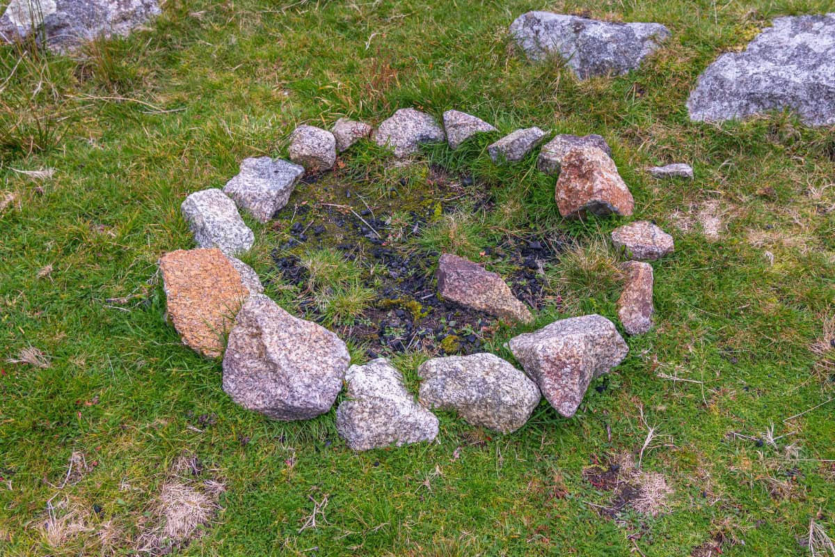 Image a timeless fire pit configuration of rocks for a blog post covering fire pit history.